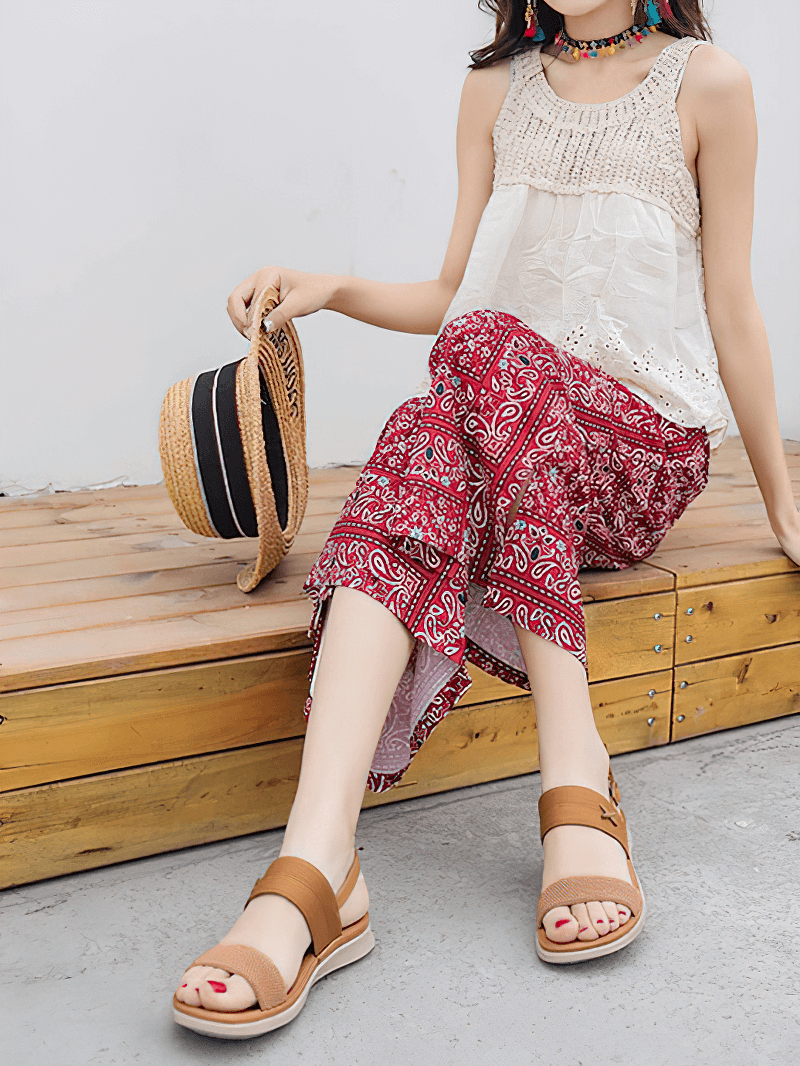 Woman wearing stylish Women's Outdoor Flat Beach Sandals with a comfortable buckle strap, paired with a trendy summer outfit on a wooden bench.